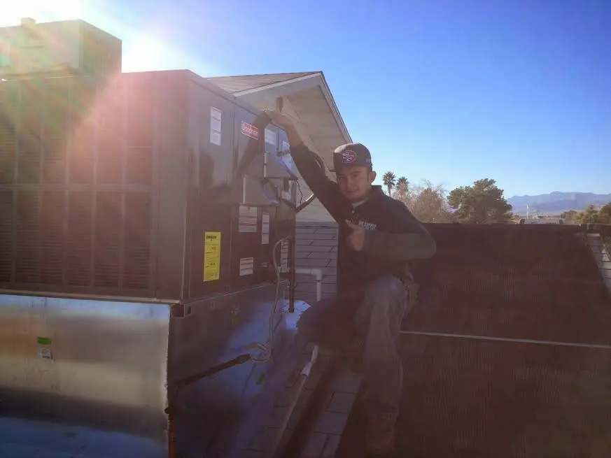 HVAC technician performing Heat Pump Repair on a rooftop unit in Laurel